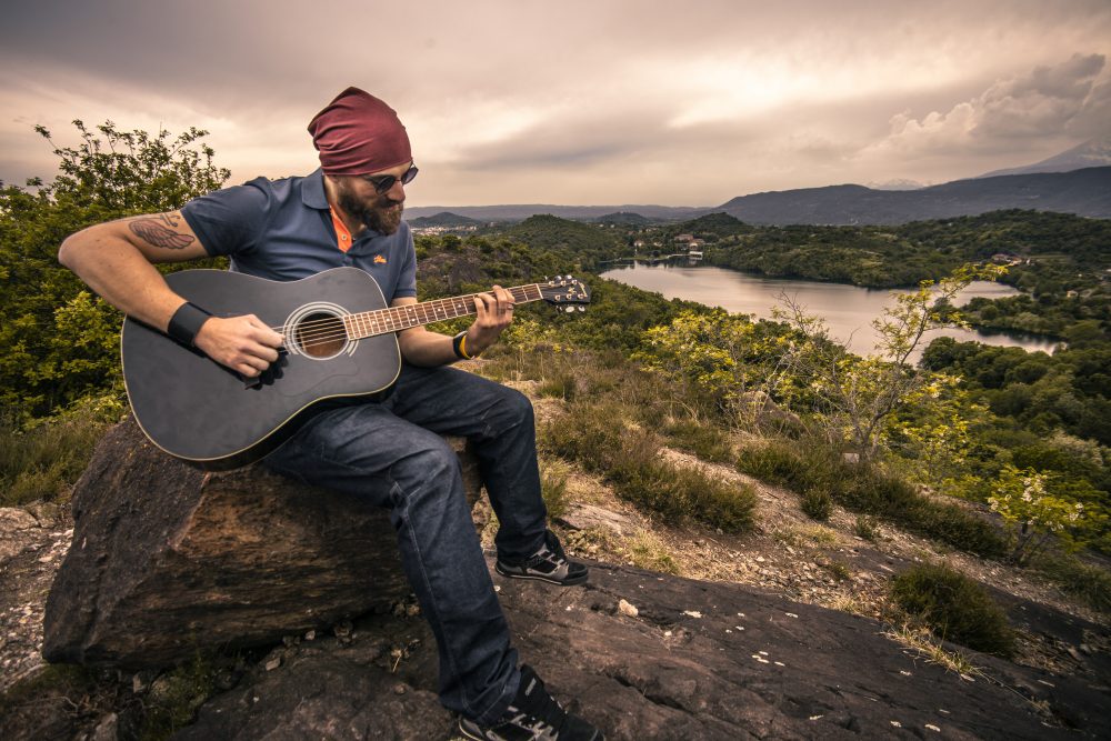 Man sitting on a rock with a lake in the background